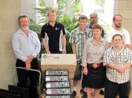 PhotoID:12955, CQUniversity reps Allan Gadsby and Aaron Karlsen (left of picture) hand over the computers to Home Support operational services manager Robyn Death and some of the service users 