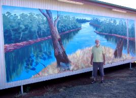 PhotoID:4044, CQU volunteer Graham Kirkwood at the Duaringa Historical & Tourism Assoc building, showing the McKenzie River mural.  