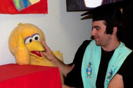 PhotoID:10876, BLM (Early Childhood) graduate Carl Jensen farewells 'Big Bird' in the Education teaching room at the Gladstone Campus.