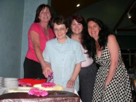 PhotoID:5008, Past BLM lecturers, Val Cleary and Helen Holden, and BLM Lecturer Lyn Hughes help Dr Bev cut her farewell cake