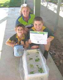 PhotoID:10761, Kylie Hopkins with grade 1 and 2 students showing off their hydroponic garden