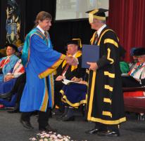 PhotoID:11474, Dr Ian McNeilly crosses the stage during graduation recently