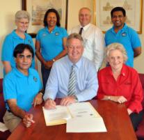 PhotoID:11481, Professor Masud Khan (front left) signing the MOU with Mayor Brad Carter and Deputy Mayor Rose Swadling. Retired academic Dawn Hay (top left) is among the supporters