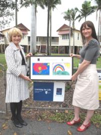 PhotoID:9691, CQUniversity's Student Support Centre Manager, Mary McLeod is presented with a framed display of children's artwork by The Smith Family's Cevall Johnstone at Berserker State School this week.