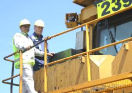 PhotoID:10338, Symposium chair Dr Sanath Alahakoon inspects a hybrid dozer with Malcolm Pollock from Gladstone Ports Corporation Ltd