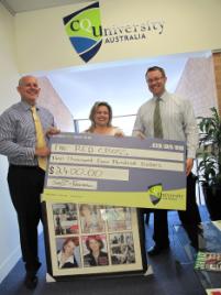 PhotoID:10444, Red Cross' Jennifer Smith accepts both a cheque and her auction item from CQUniversity's Government Relations Manager Martin Elms (right) and Vice-Chancellor Professor Scott Bowman