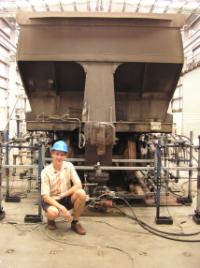 PhotoID:10938, A rail researcher works with a test rig, exerting tilting and rotating forces on a rail wagon and track segment to mimic the forces on the bogie (wheels and wagon supports) caused by curves in the track