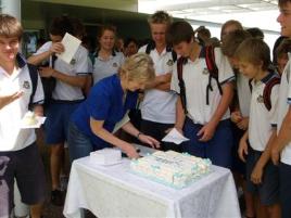 PhotoID:5200, Student counsellor Michele Palu serves cake to Bundaberg State High  students celebrating completion of TAP