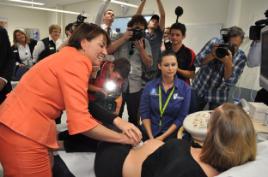 PhotoID:10877, Sonography student Catherine Jacquier looks on as Premier Bligh tries out some of the new medical imaging equipment, amid much media interest