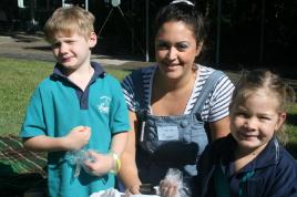 PhotoID:10846, CQUniversity Early Childhood Education student Renee Chagoury plants seedlings with Noosaville State School prep students Reuben Todd (left) and Amelia Aufderheide.